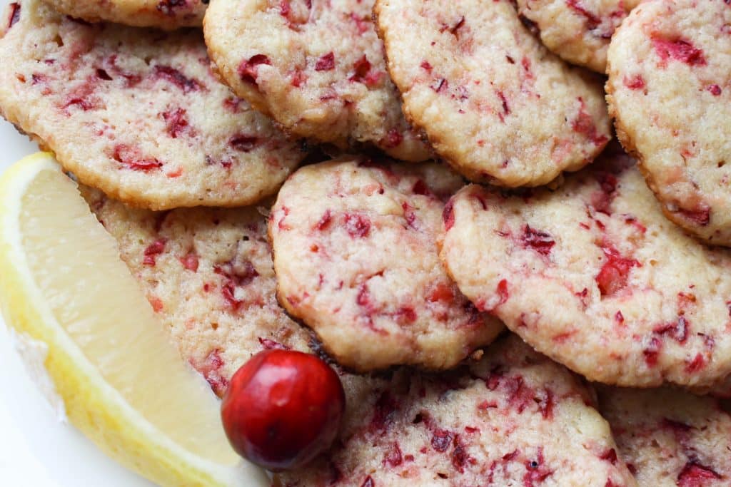 close up of einkorn cranberry shortbread cookies with lemon and cranberry garnish