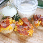 sourdough mini breakfast pizzas next to glass of milk and an egg