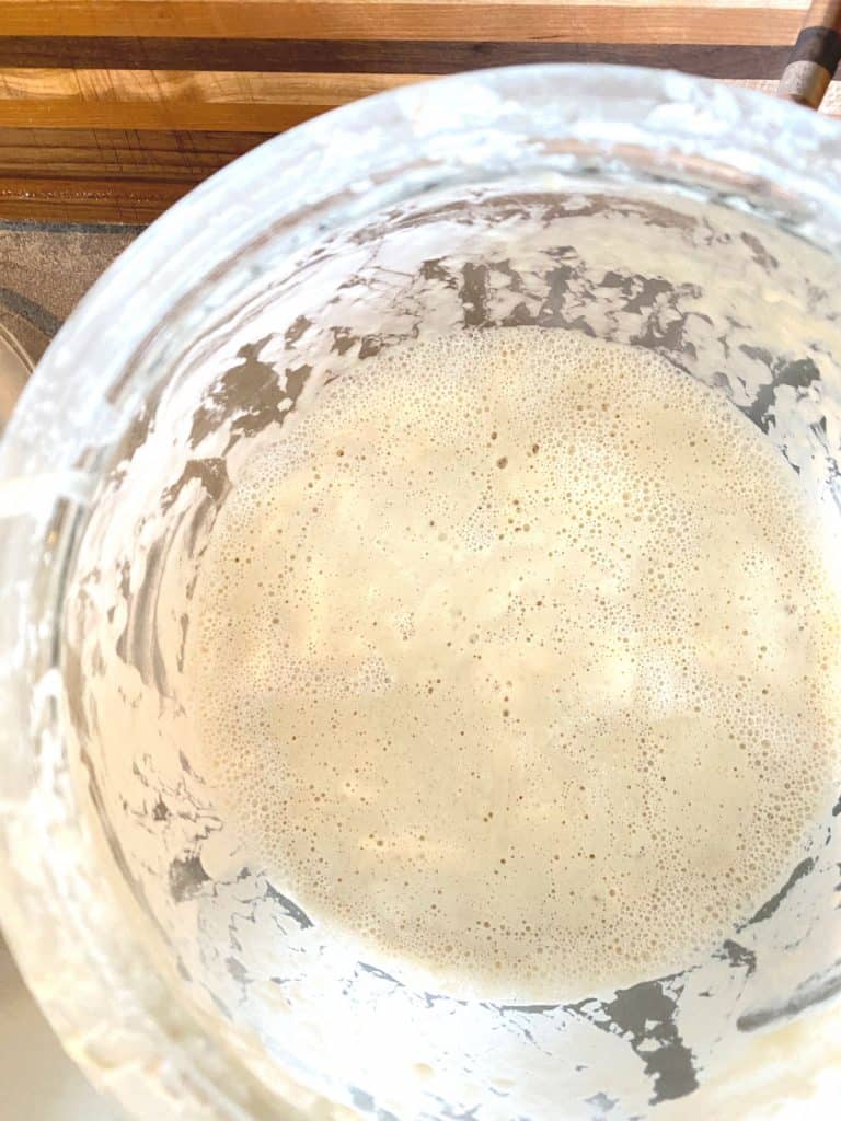 bubbly active sourdough starter in glass jar