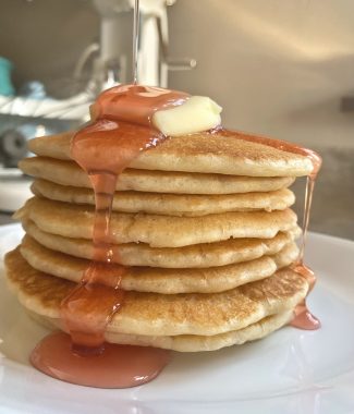sourdough discard pancakes topped with butter and peach syrup