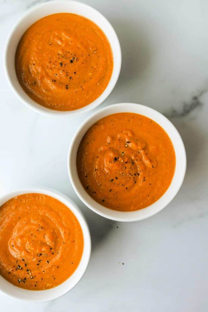 spiced carrot and lentil soup in white bowls