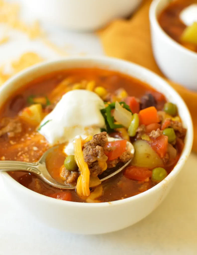 cowboy hamburger soup topped with sour cream and cheese