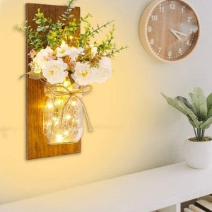 rustic floral wall sconce with clock and plant in background