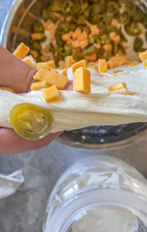 cheese and jalapenos being folded into sourdough