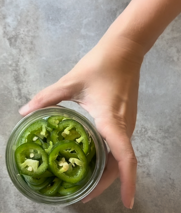 An open jar of sliced jalapeños
